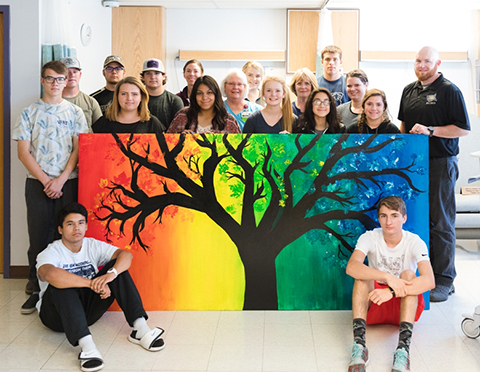 Echo High School students and Teacher, Rick Thew, along with Good Shepherd Health Care System Wound Care staff pose with one of the two murals that were donated to the hospital.